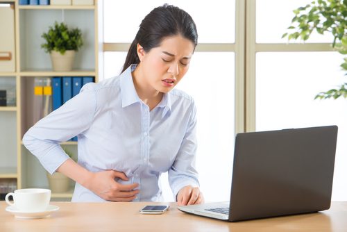 Ragazza al pc con mal di stomaco