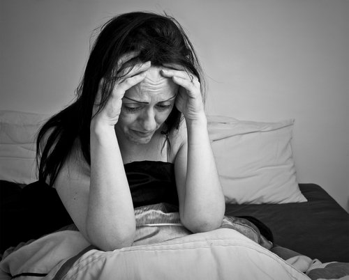 Donna con mani sulla fronte