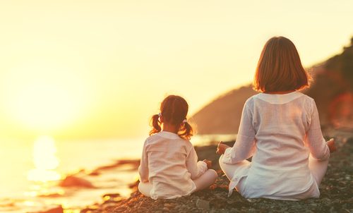 Bambine sul mare praticando yoga