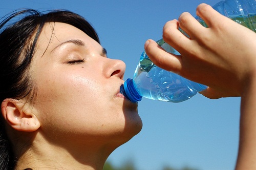 Donna beve acqua dalla bottiglia