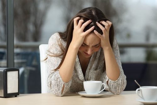 Donna che piange al tavolo di un bar