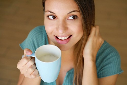 Giovane beve una tazza di latte.