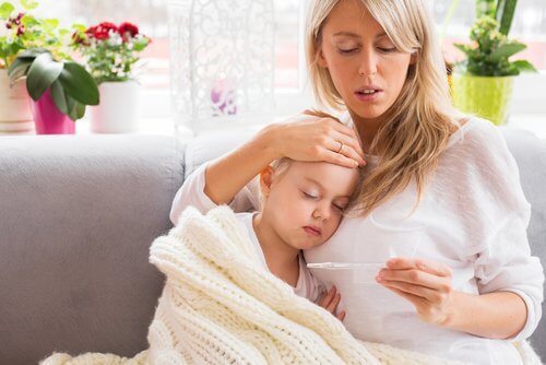 Mamma misura la febbre a sua figlia - sintomi della meningite