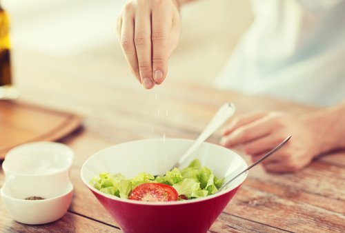 Uomo che mette sale in insalata