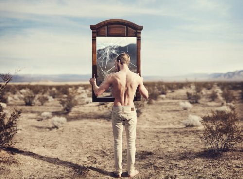 Uomo regge specchio rotto