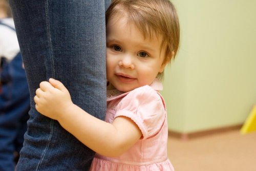 Bambina si nasconde dietro la gamba della madre