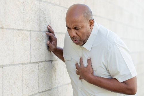 Emergenza cardiaca: uomo si stringe il petto.