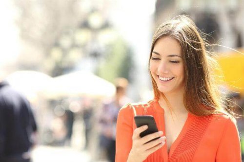 Ragazza sorride guardando il cellulare