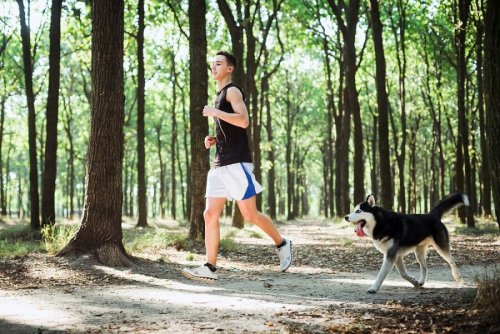 ragazzo che corre nel bosco con il cane