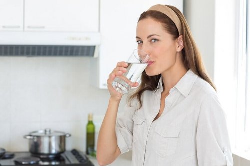 Donna che beve acqua per espellere i calcoli renali.