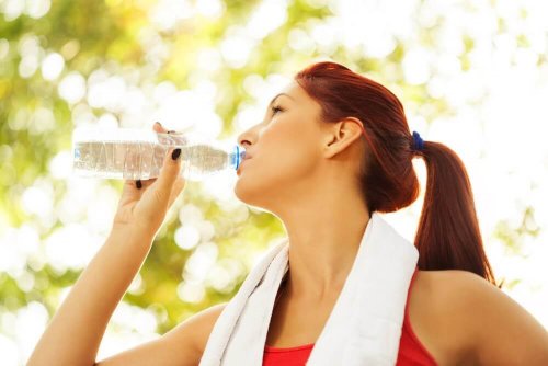 Donna che beve acqua all'aria aperta