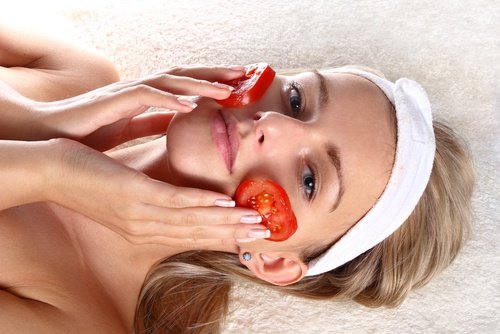 Donna con fette di pomodoro sulla faccia