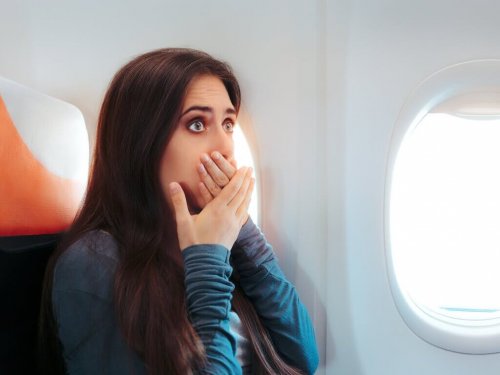 Donna in aereo che fa respiri profondi per trattenere vomito