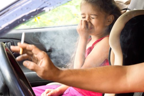 Padre fuma in macchina e figlia si tappa il naso