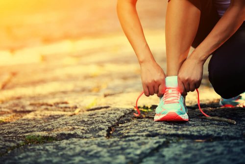 donna si allaccia scarpe da ginnastica