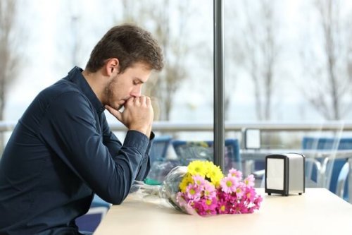 Uomo pensieroso con mazzo di fiori