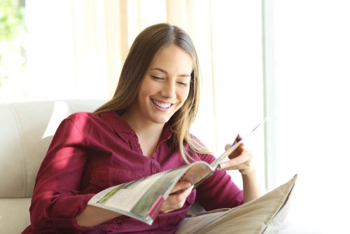 ragazza sorridente legge rivista