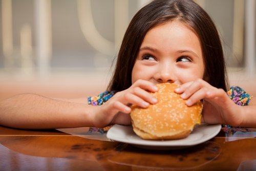 Bambina mangia hamburger