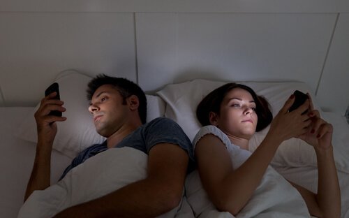 due persone a letto con il cellulare