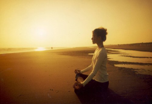 Donna che medita sulla spiaggia
