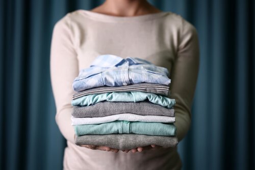 Donna con indumenti piegati in mano