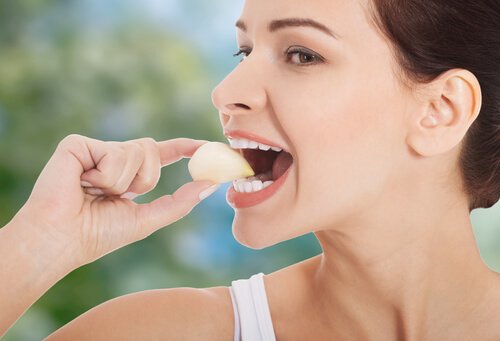 donna mangia spicchio di aglio intero