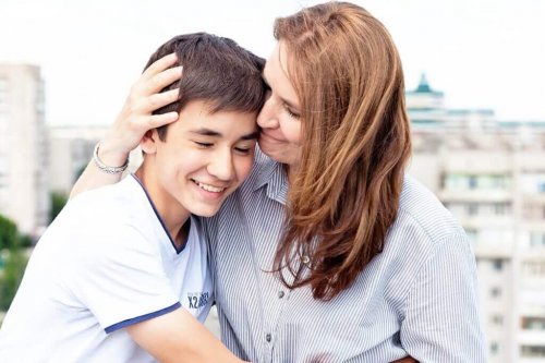 Madre abbracciata a figlio adolescente