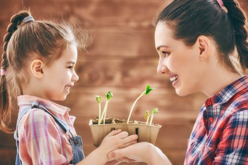 Mamma e figlia che tengono una piantina