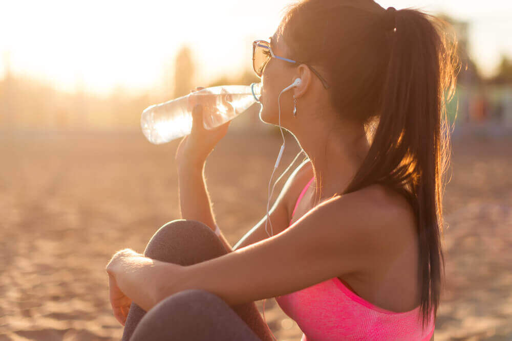 Ragazza beve acqua da una bottiglia