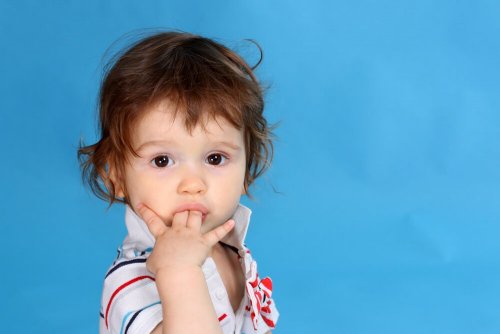 Bambino con le dita in bocca che continua a succhiarsi il pollice