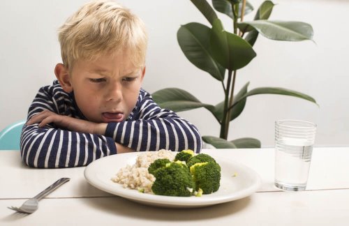 Bambino disgustato davanti a un piatto di verdure