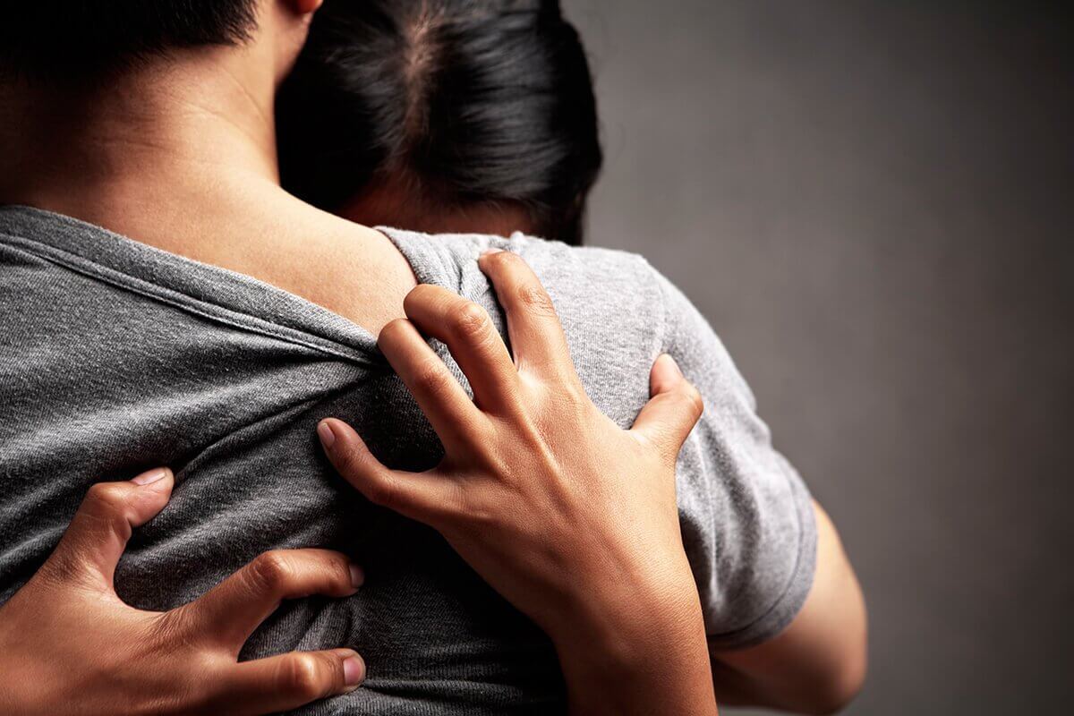 donna che si aggrappa a corpo di uomo
