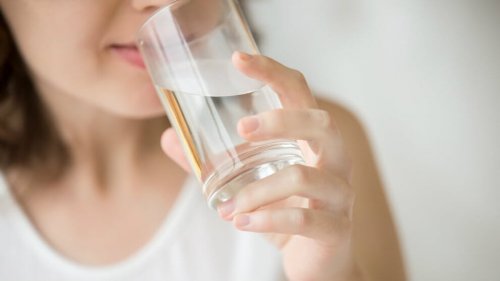 Donna che beve acqua per perdere peso in menopausa.