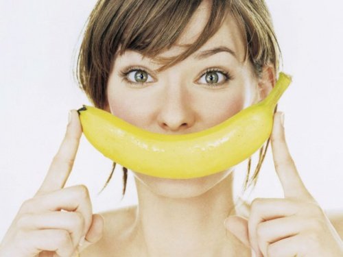 Donna con banana vicino al viso