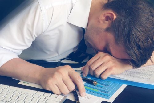 Uomo con testa sulla scrivania soffre di stress