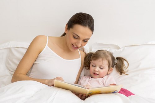 Mamma che legge una favola alla figlia a letto