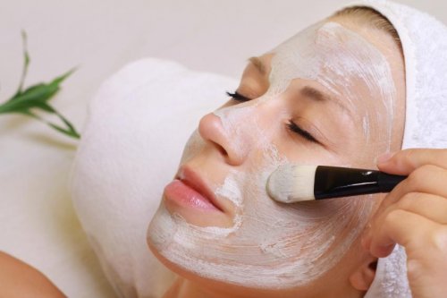 Donna applica maschera sul viso con un pennello