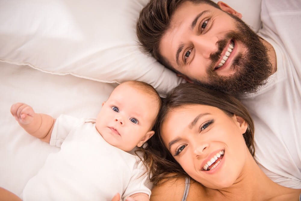 Neo-genitori sorridenti con bambino