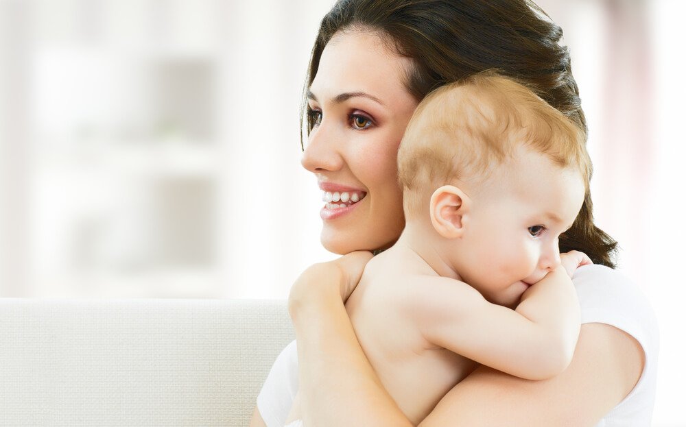 Neomamma sorridente con bambino