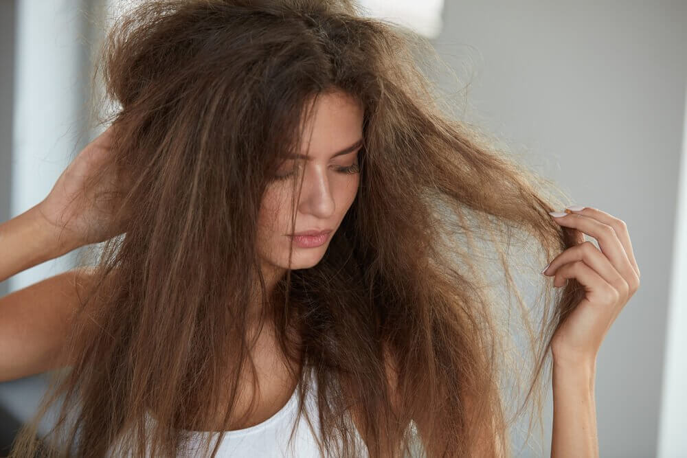 Ragazza con capelli secchi e crespi