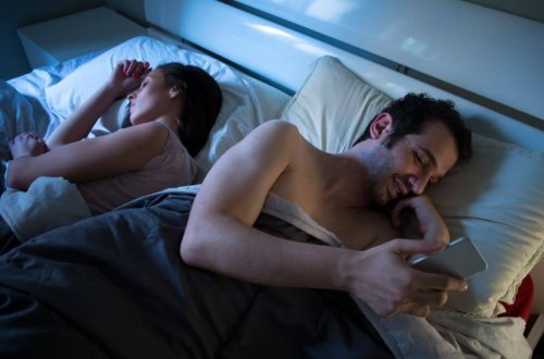 Coppia a letto e uomo con il cellulare