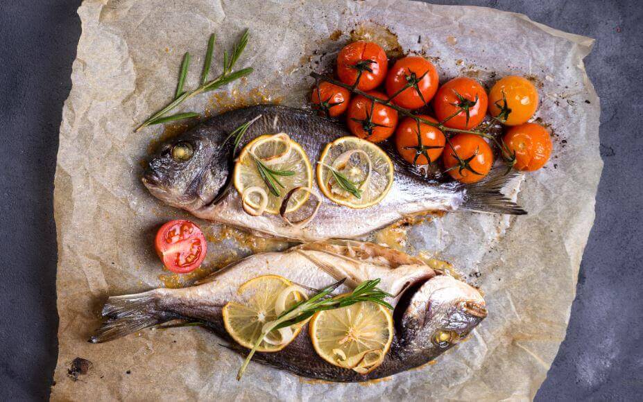 Pesce e verdure su carta da forno