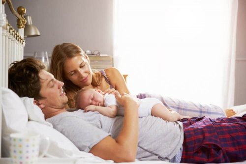 Bambino neonato che dorme con i suoi genitori