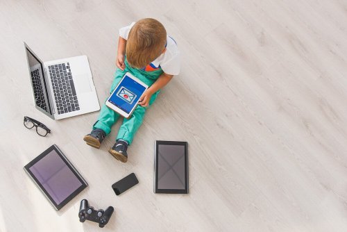 Niño juega con PC y tableta