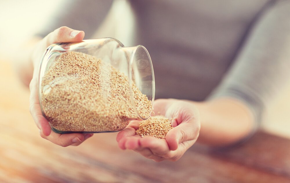 Donna che si versa quinoa nella mano