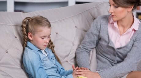 Madre e figlia unica sedute sul divano.