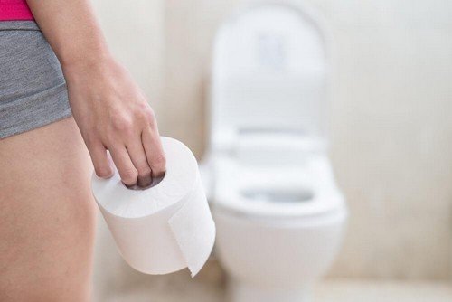 Donna con rotolo di carta igienica