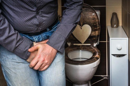 Uomo piegato a causa dell'incontinenza urinaria