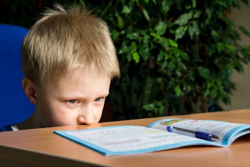 Bambino seduto davanti al quaderno aperto