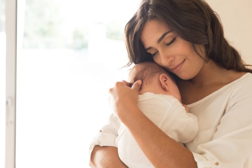 Donna abbraccia un neonato con tenerezza